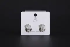 Pair of silver-toned geometric stud earrings featuring a round crystal pave disc and a small white pearl drop on a display card., image 1